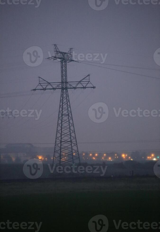 Landscape with power lines in dusk in Mecklenburg-Vorpommern, Germany. The city in the background is Greifswald. photo