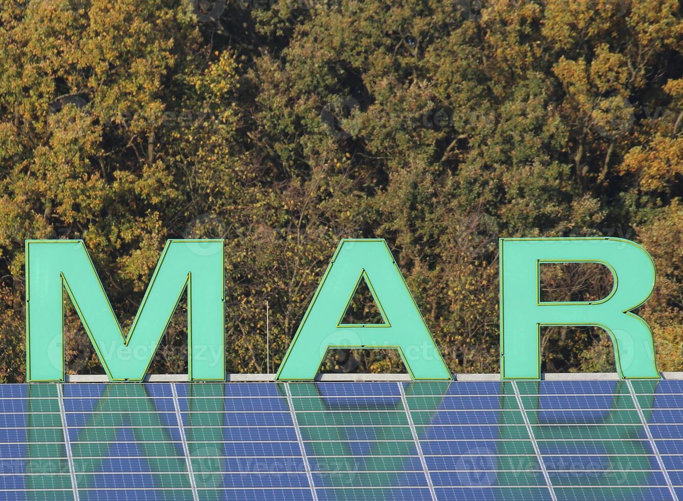 Letters MAR - a name fragment - on a roof reflected by solar panels. photo