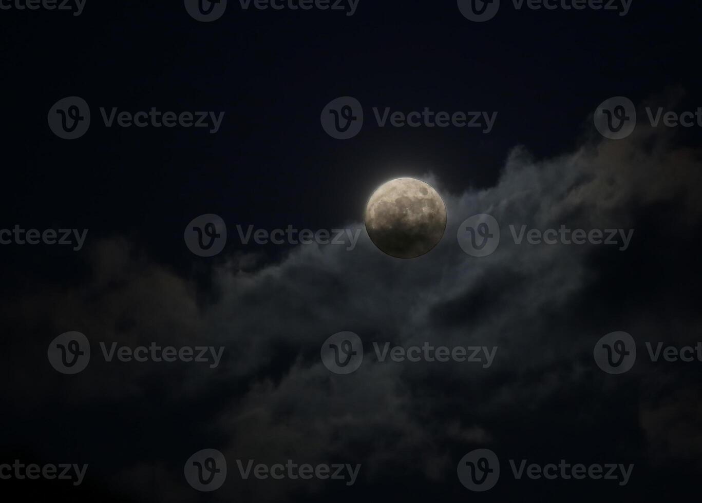 Full moon behind a cloud made visible by an HDR imaging technique. photo