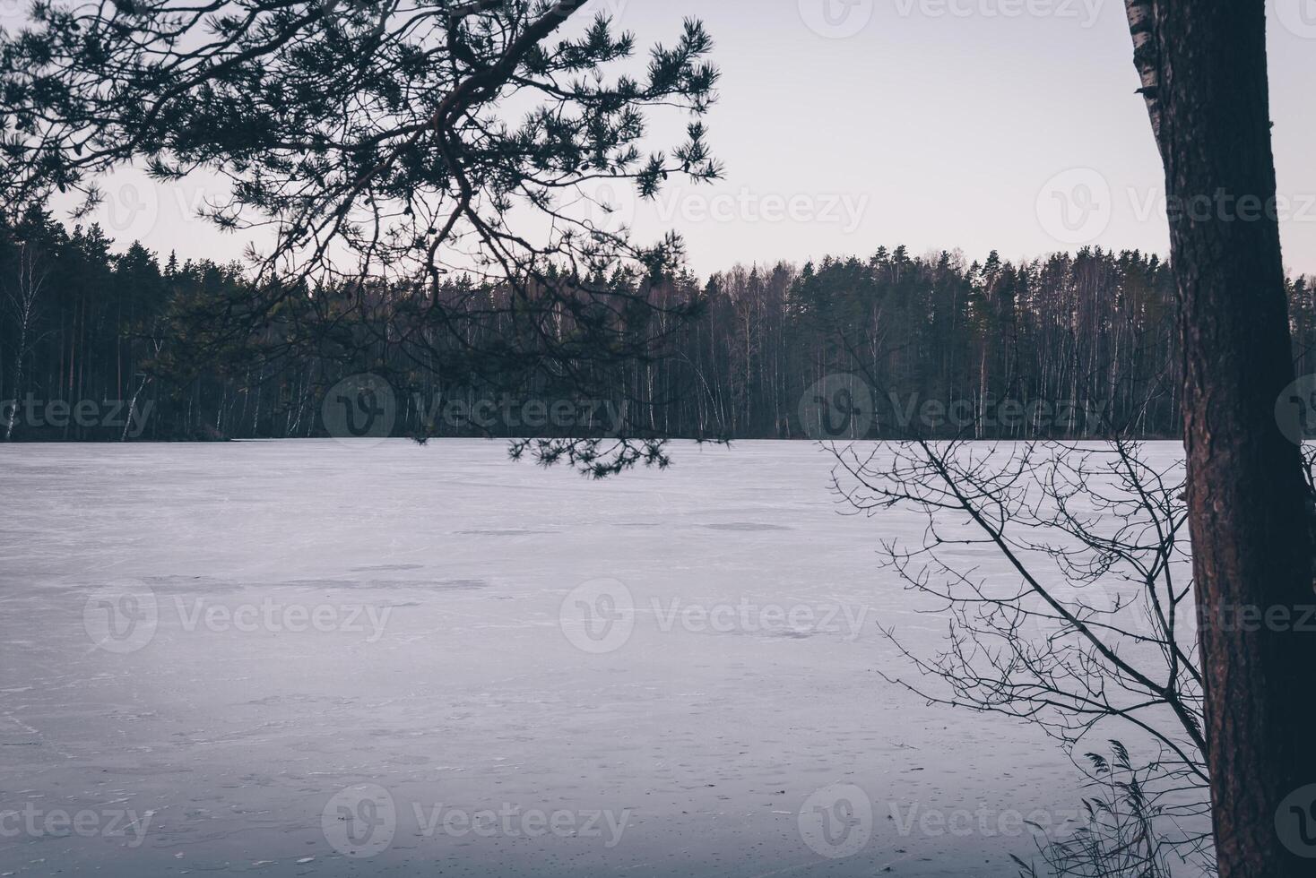Landscape of blue deep ice lake in winter in daytime, clouds in sky tide, mountains photo
