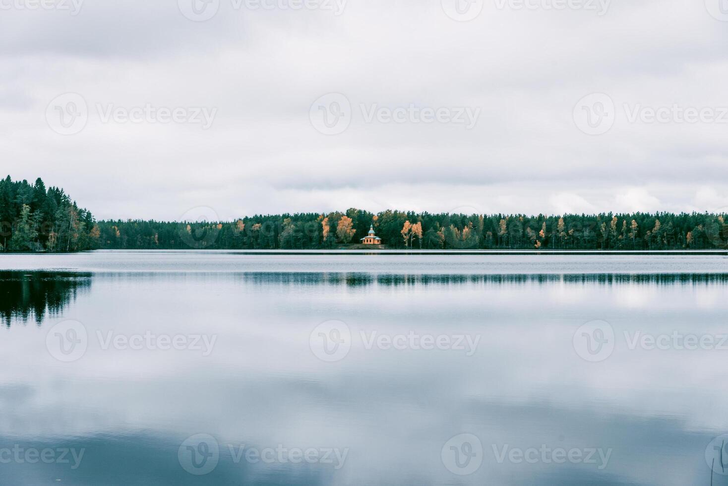 Landscape of blue deep lake in light of sun in tide daytime, clouds in sky, mountains photo