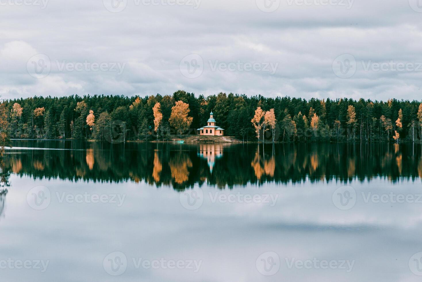Landscape of blue deep lake in light of tide sun in daytime, clouds in sky, mountains photo