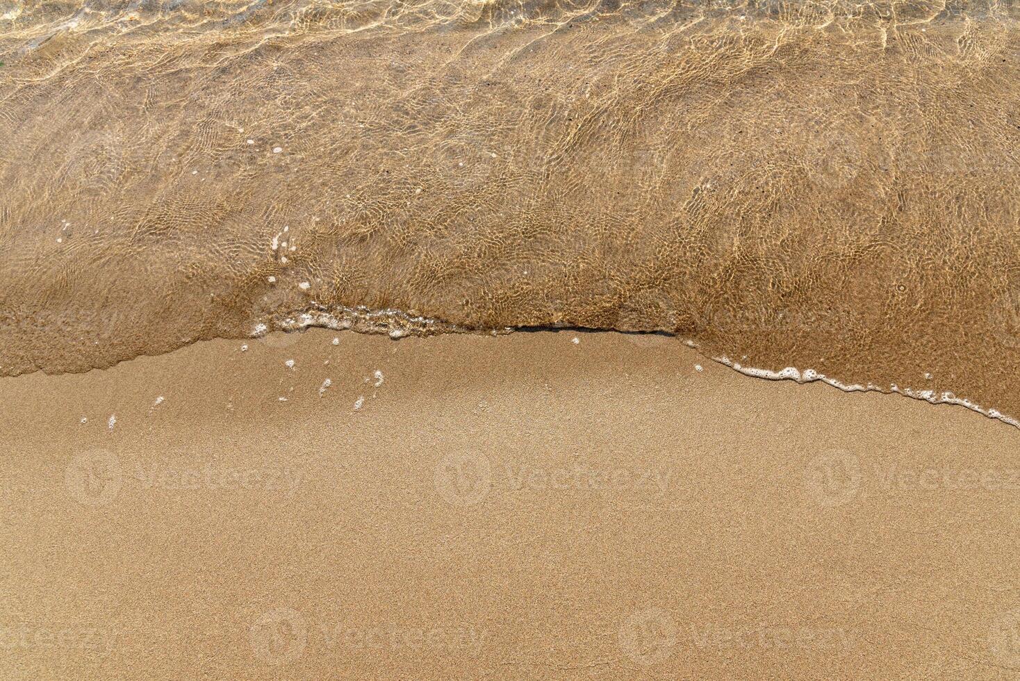 Sandy yellow beach with sea in cute background, wave ocean in sand photo