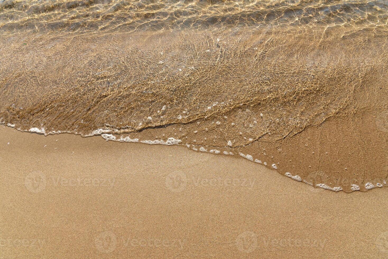 Sandy yellow beach cute with sea in background, wave ocean in sand photo