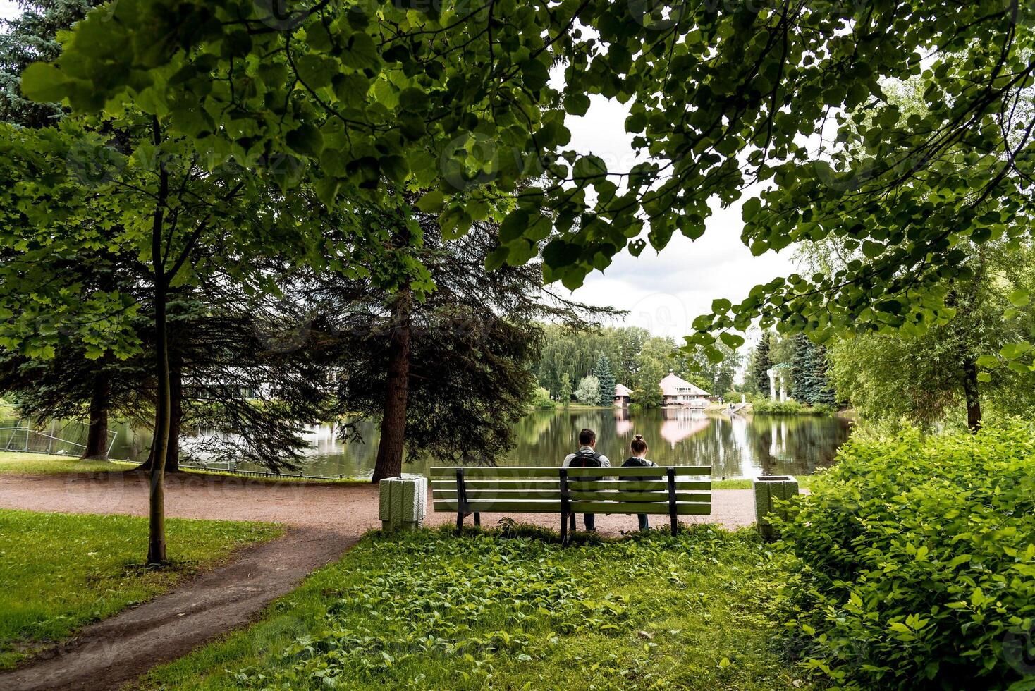 Green city park with nice walking path, trail next to decorative building, cloudy day photo
