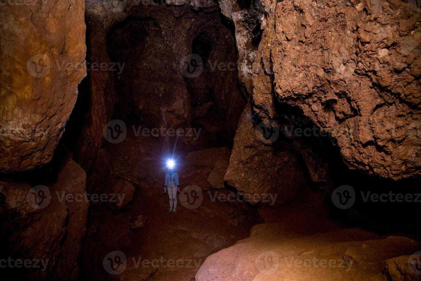 Speleologist explores an underground cave journey, geologist studies hole rock mountain photo