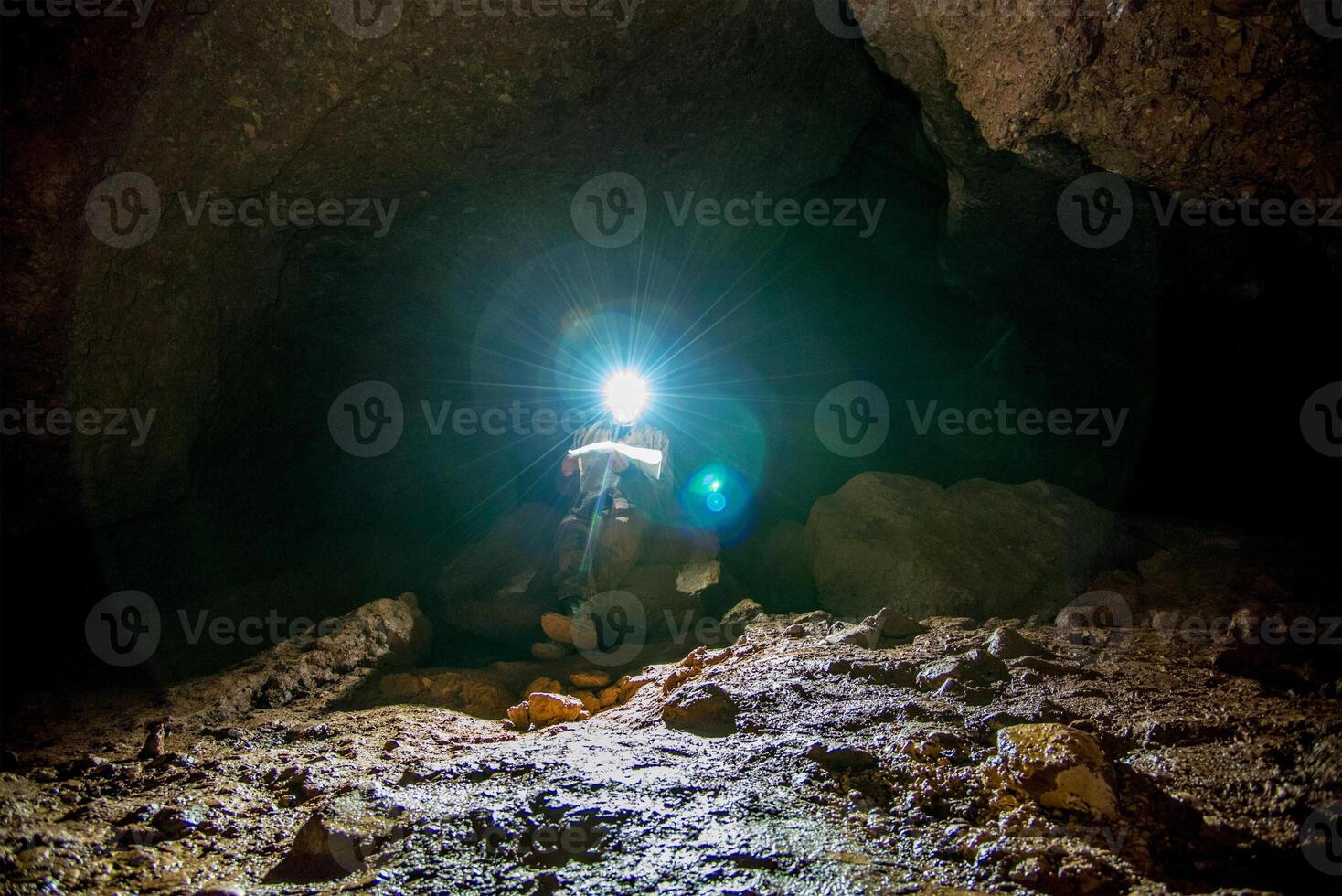 Speleologist explores an underground cave, geologist journey studies hole rock mountain photo