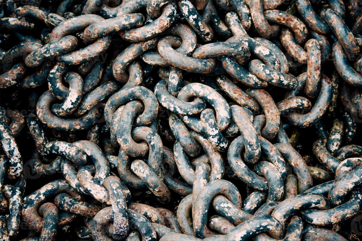 Large big rusty metal chain from ship anchor lying in wooden box, rebar texture photo