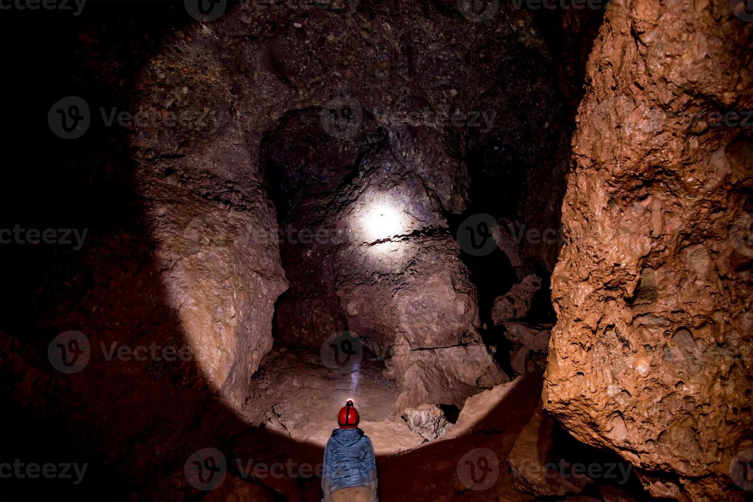 Speleologist explores an journey underground cave, geologist studies hole rock mountain photo