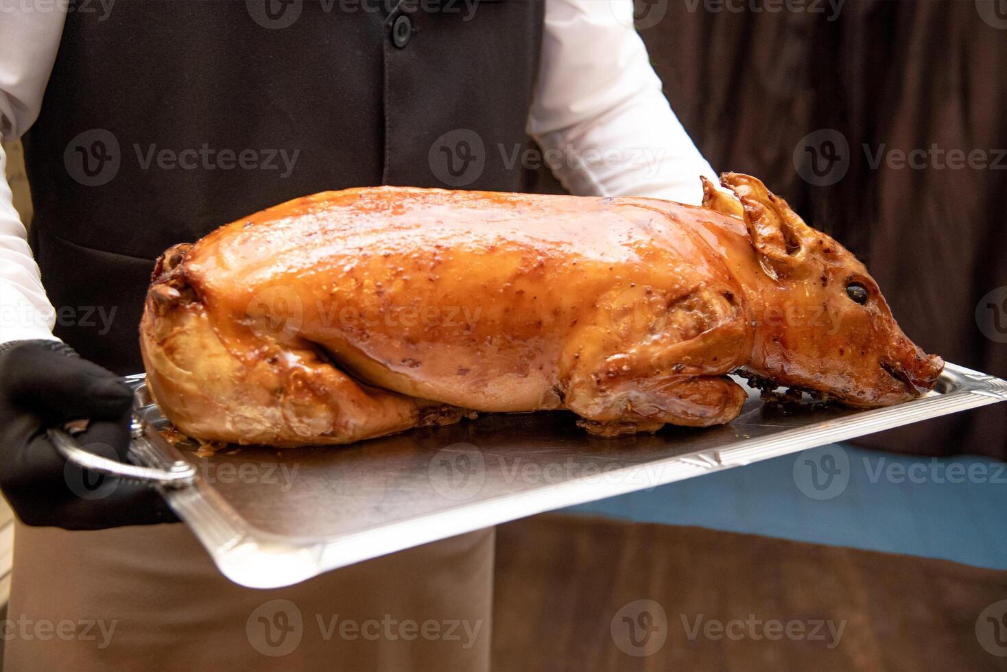 Roast whole pig dish in glass plate, lunch for large company in restaurant photo