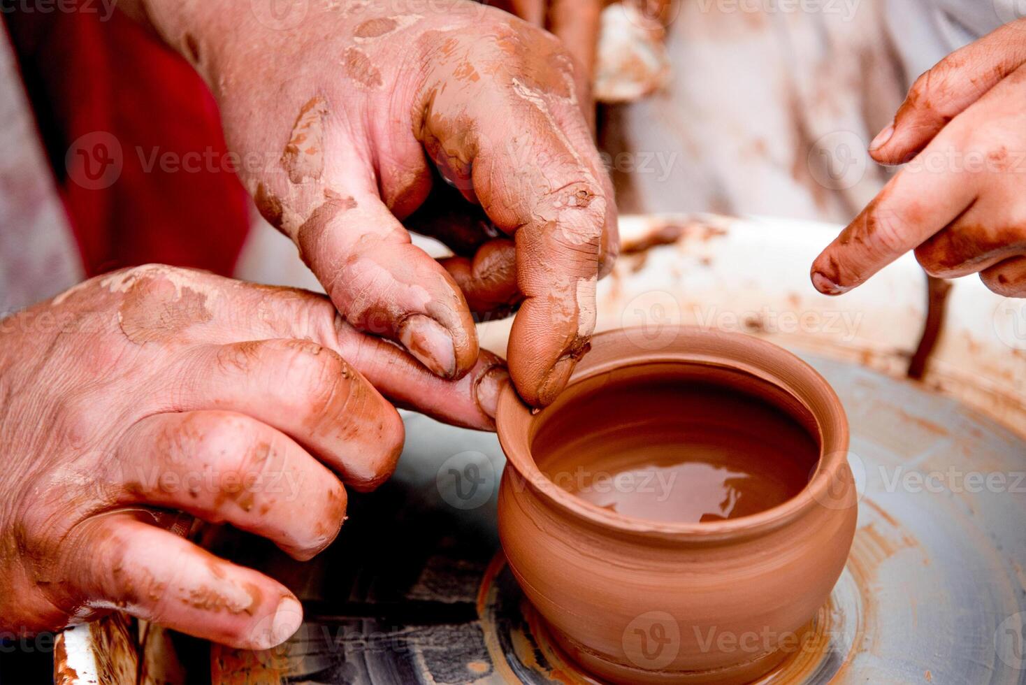 Potter sculpts mug from clay nice, close up dirty hands create vase on ceramist wheel photo