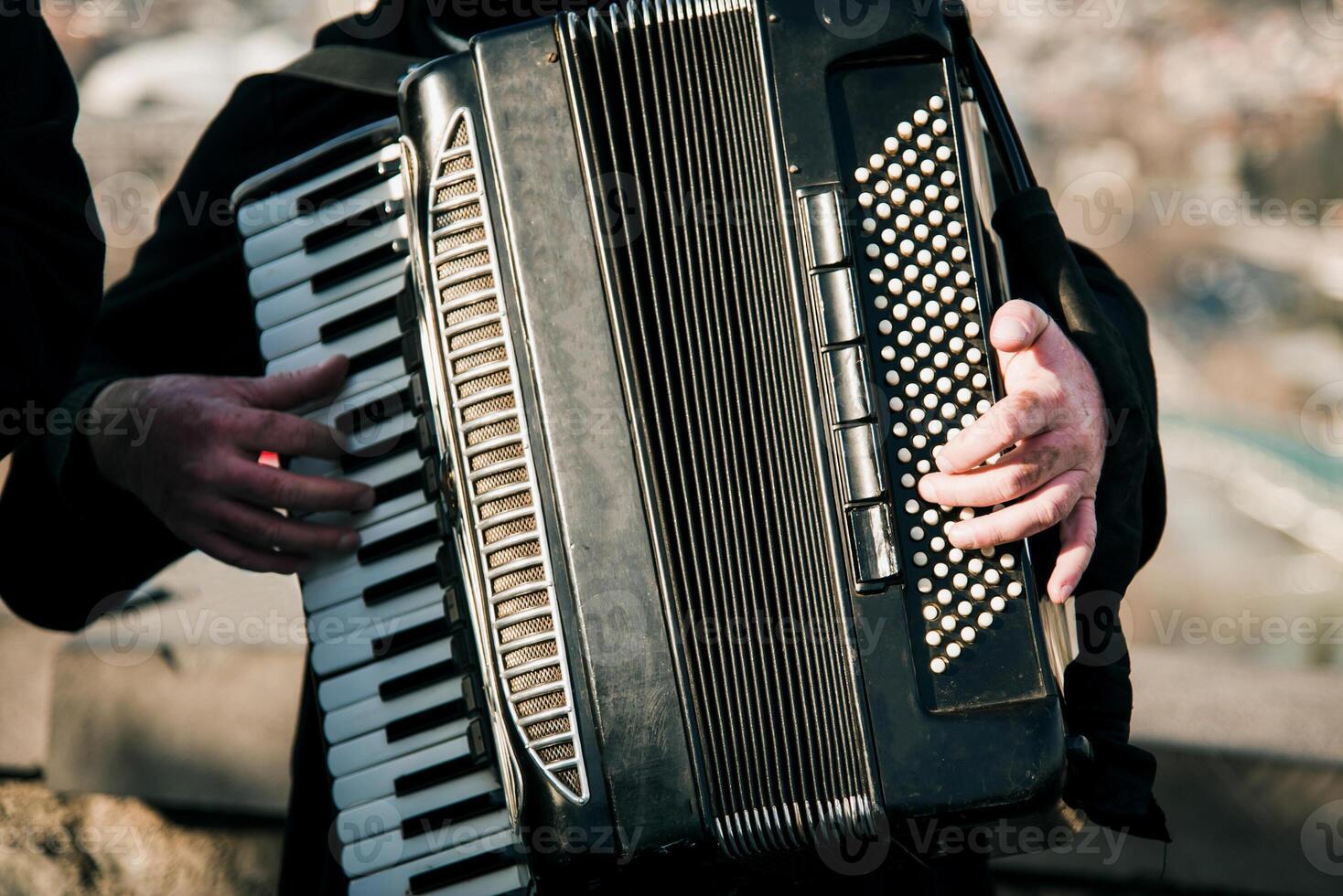 Man play keys accordion, musician guitarist performs at concert outside photo