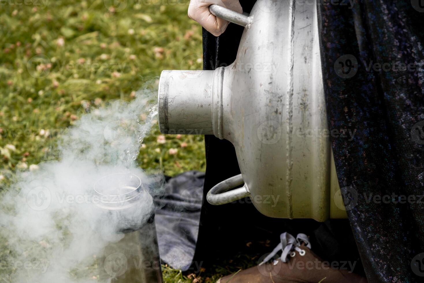 Scientist pour liquid nitrogen large barrel flask, assistant conducts experiment photo