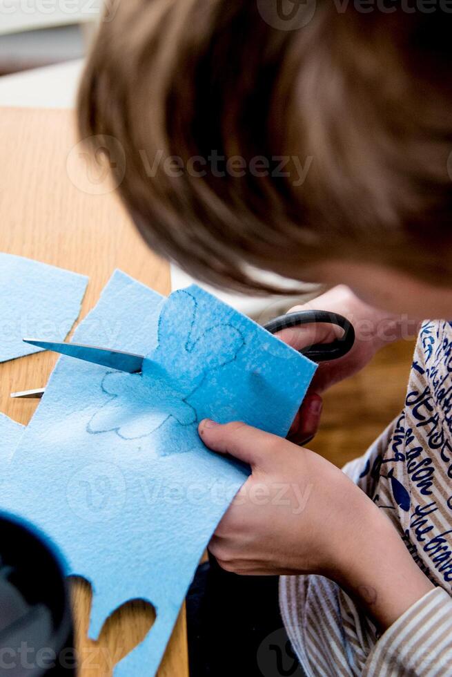 Child makes craft from colored paper, kid draw kindergarten, lovely preschool education photo