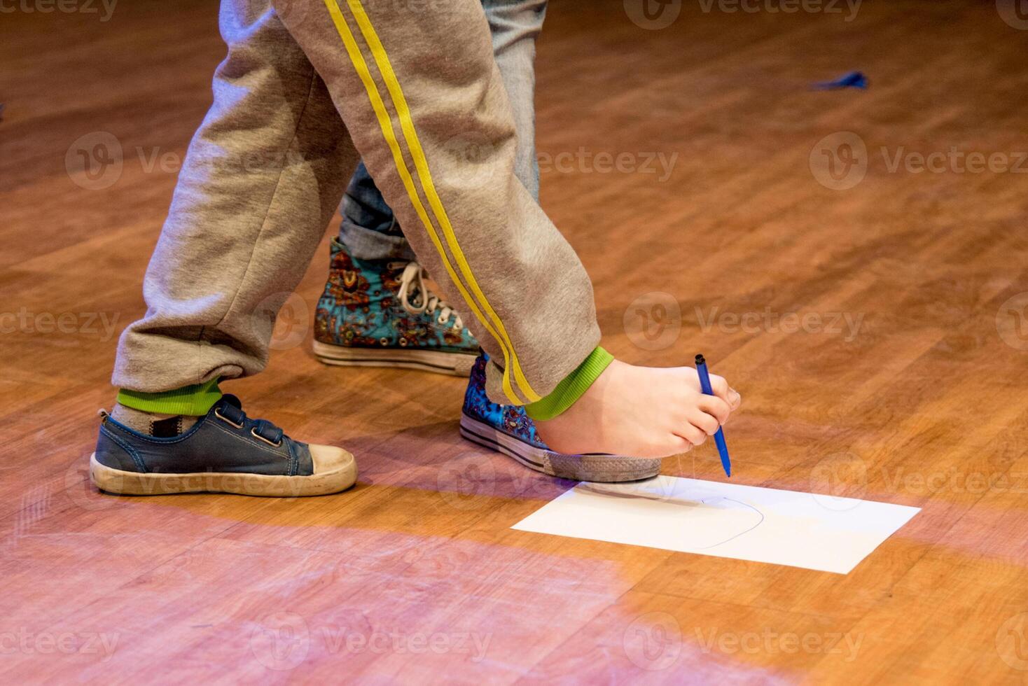 Child draw lovely foot felt tip pen on paper, kid in kindergarten, preschool education photo