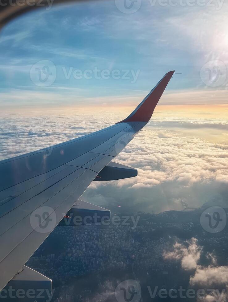 A breathtaking view from an airplane window over clouds and a city, capturing the serenity of a morning flight photo