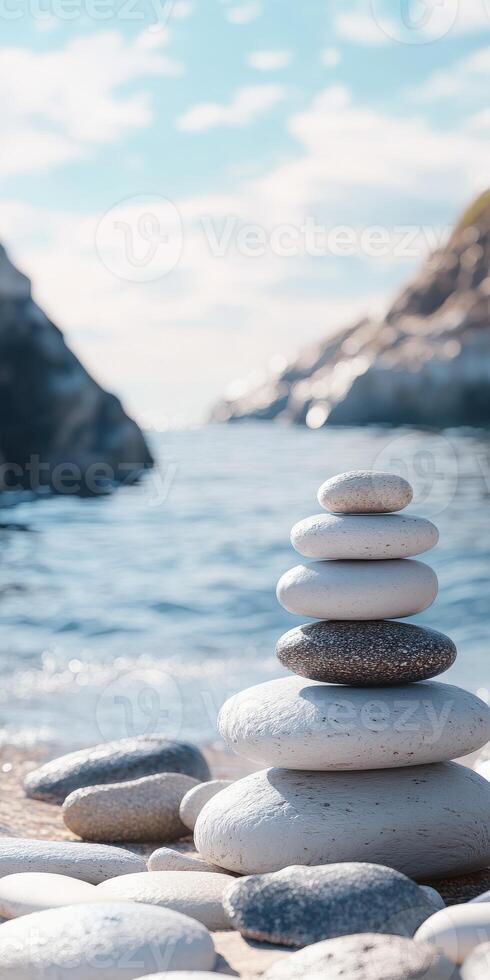 Balanced stones stacked on a beach near a calm sea under clear sky photo