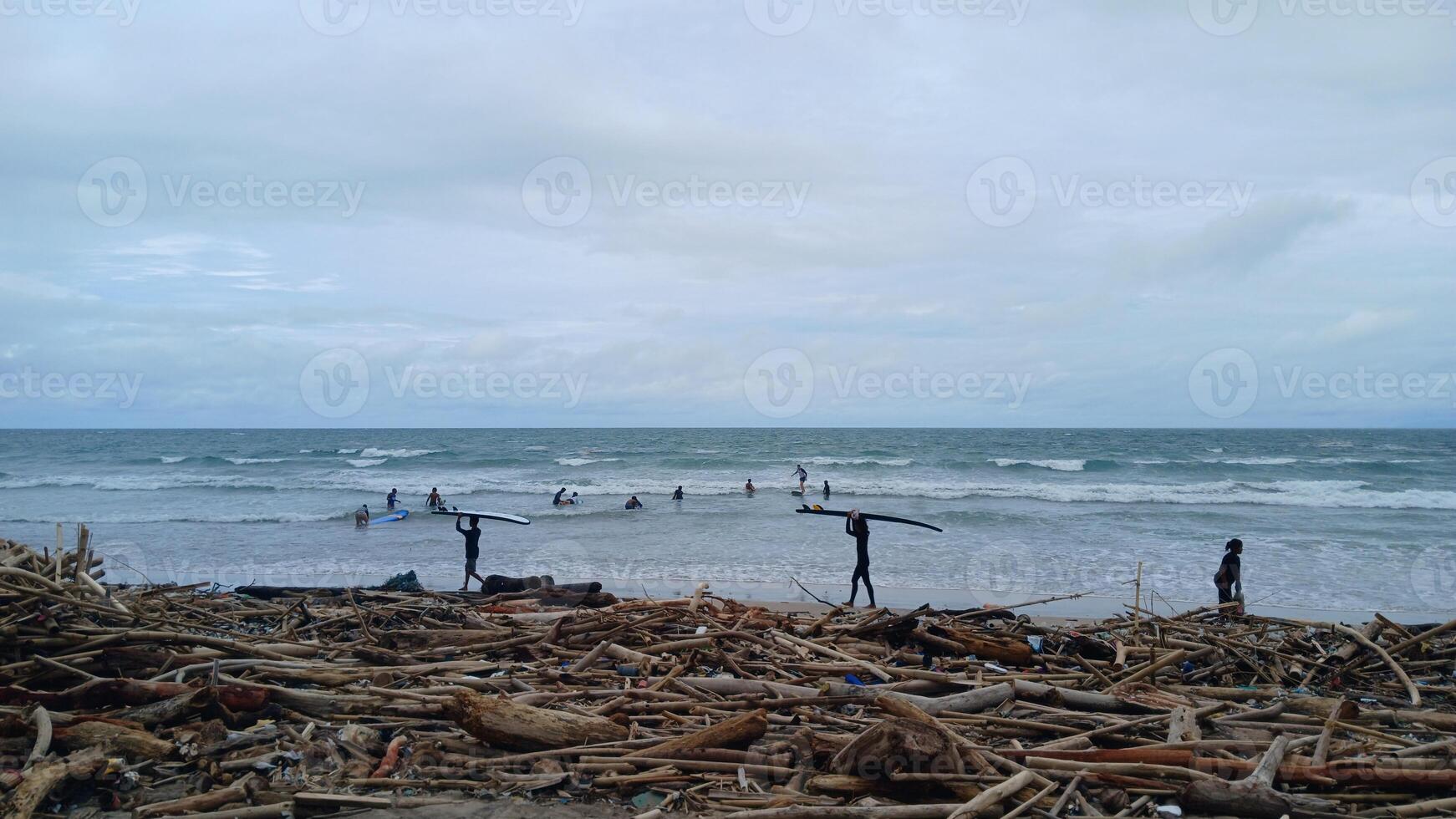 A debris and the surfer with their surfboards in the beach photo