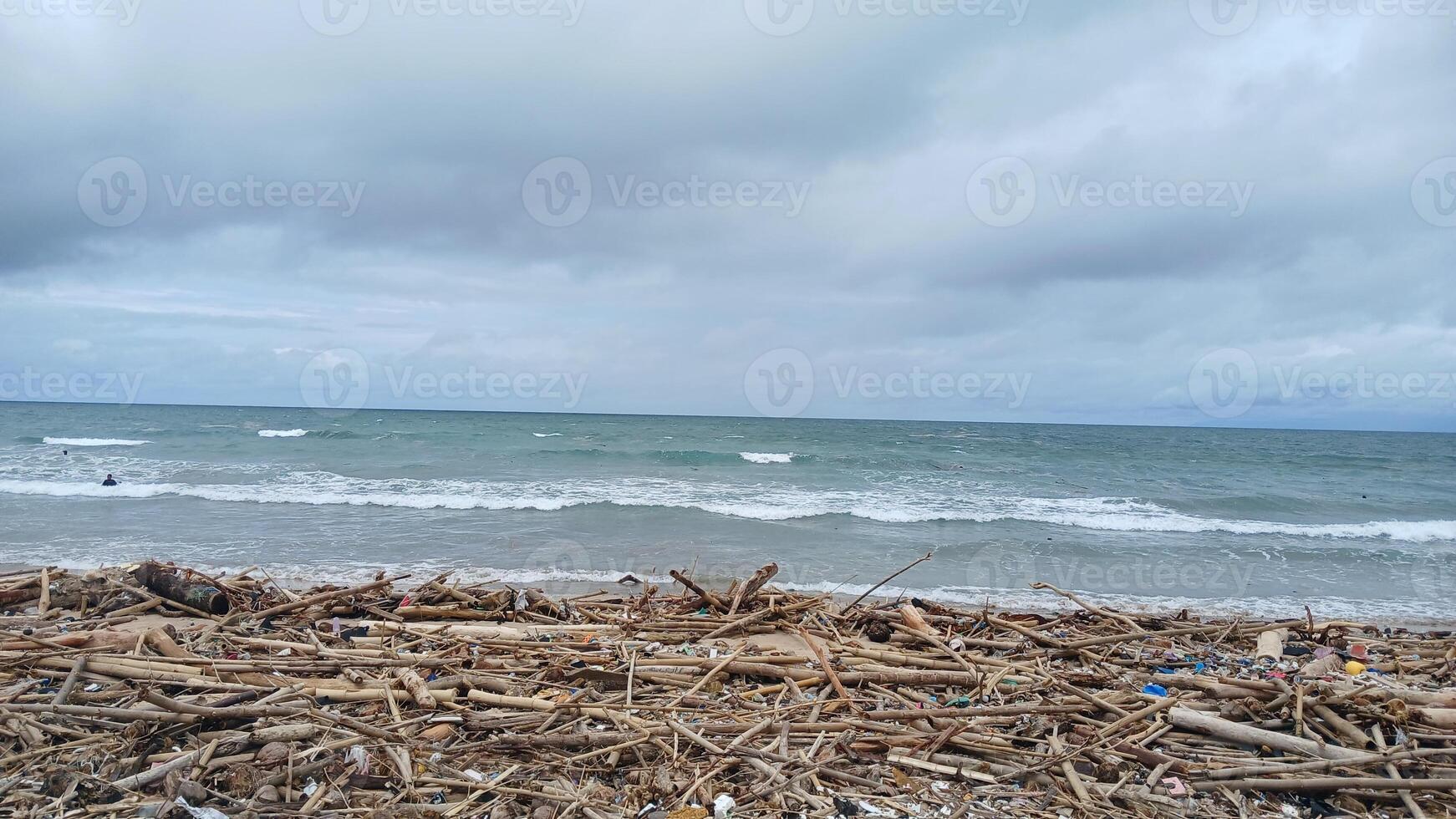 A beach with debris and a body of water photo