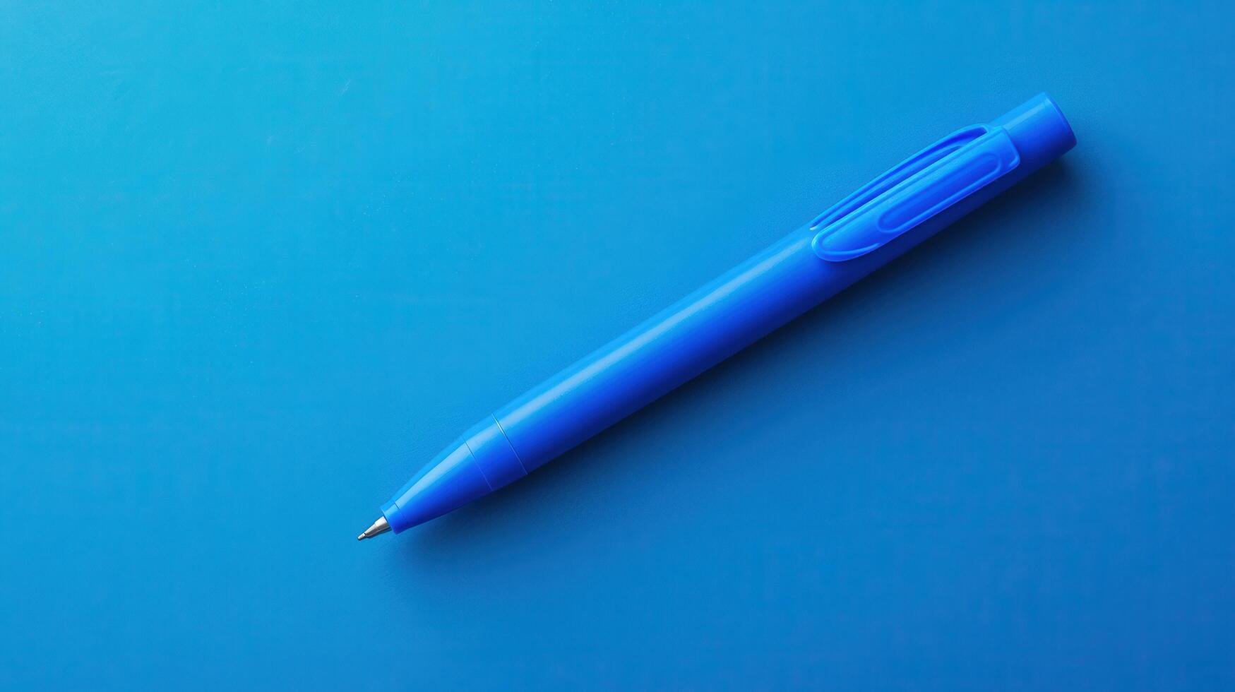 Blue pen resting on a vibrant blue surface creating a minimalistic aesthetic atmosphere in an office setting or study area photo