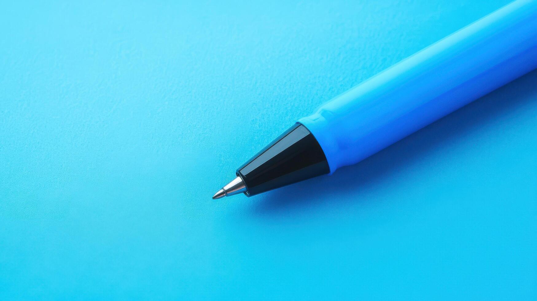 Close-up of a blue pen resting on a smooth blue surface in a creative workspace showcasing vibrant colors photo
