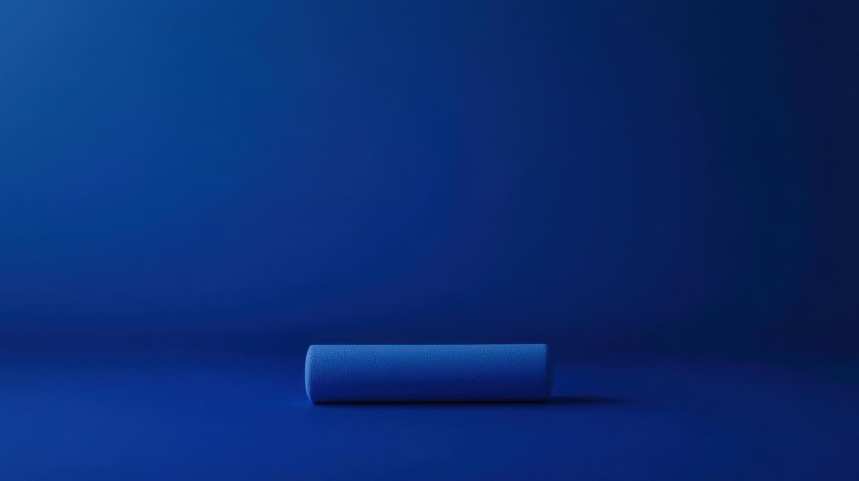 Calm and minimal blue abstract composition featuring a single rolled object on a dark blue surface photo