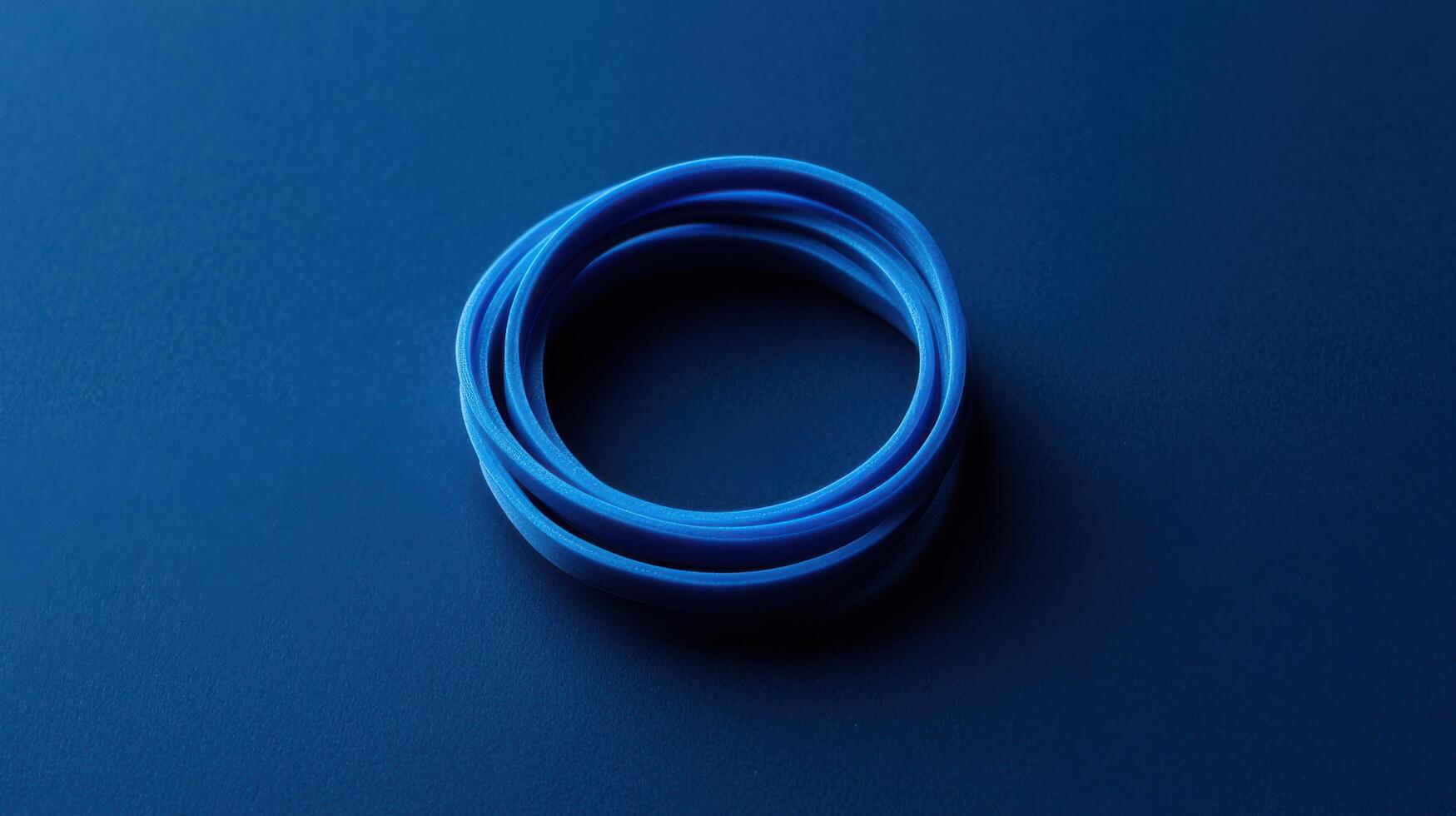 Blue rubber bands arranged in a circular shape on a dark background creating contrast and simplicity photo