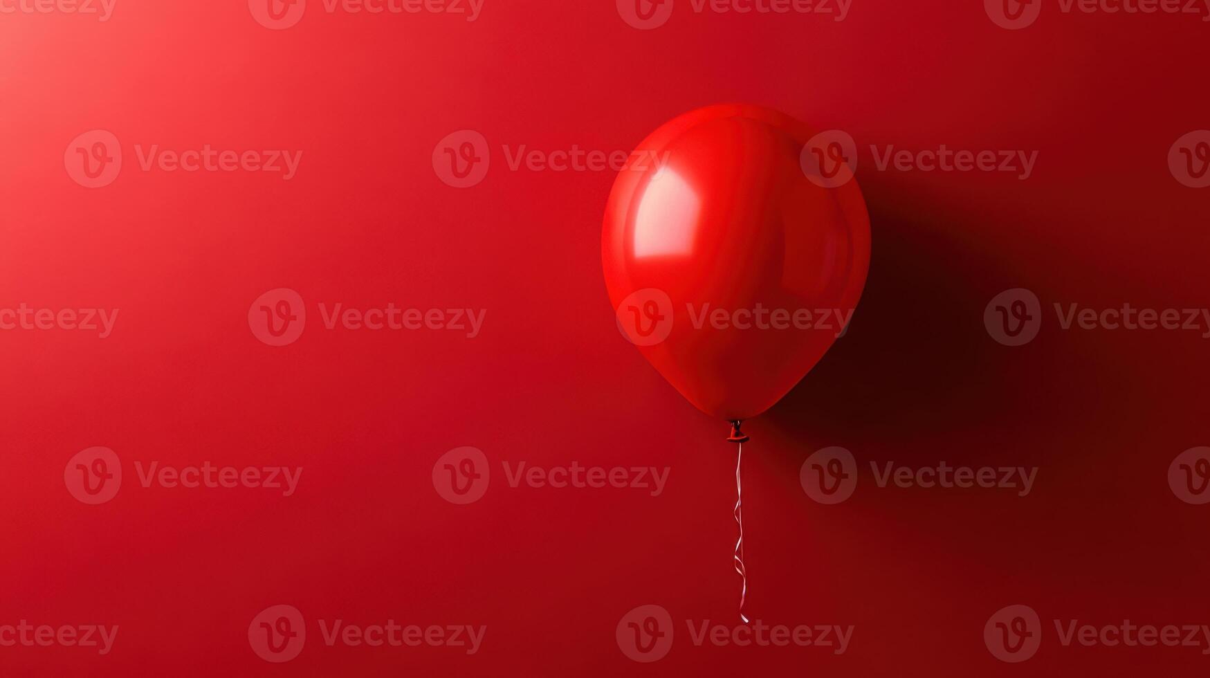 Bright red balloon floating against a vibrant red background provides a whimsical touch to the festive atmosphere photo