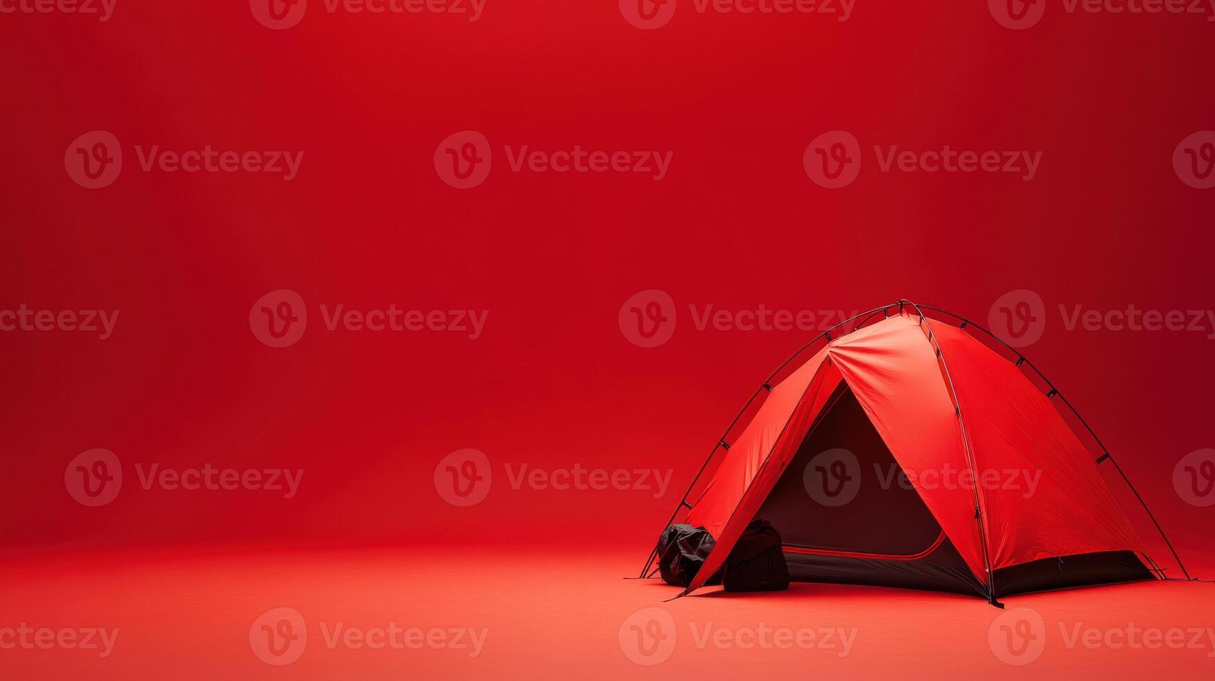 Red camping tent set up indoors with a vibrant background providing an artistic atmosphere for outdoor enthusiasts photo