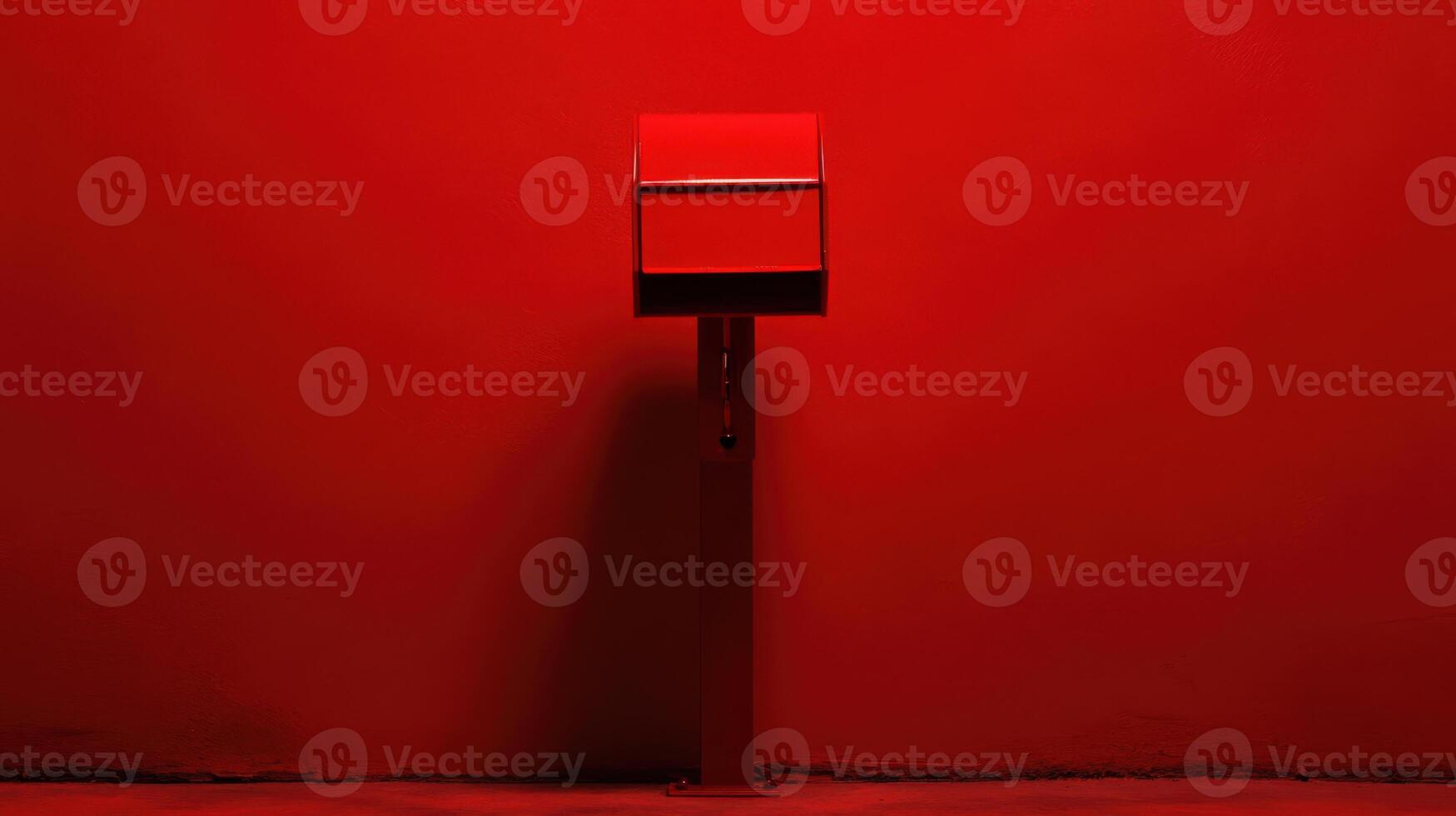 Red mailbox stands against a vibrant red wall in a minimalist urban setting photo