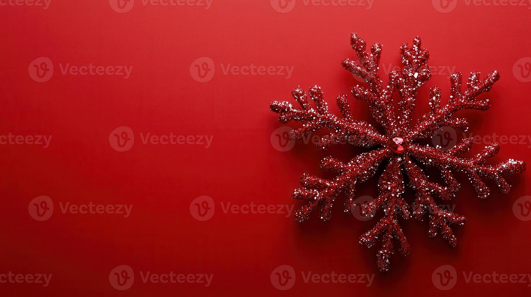 Red glitter snowflake decoration on a vibrant red background ready for winter festivities and holiday celebrations photo