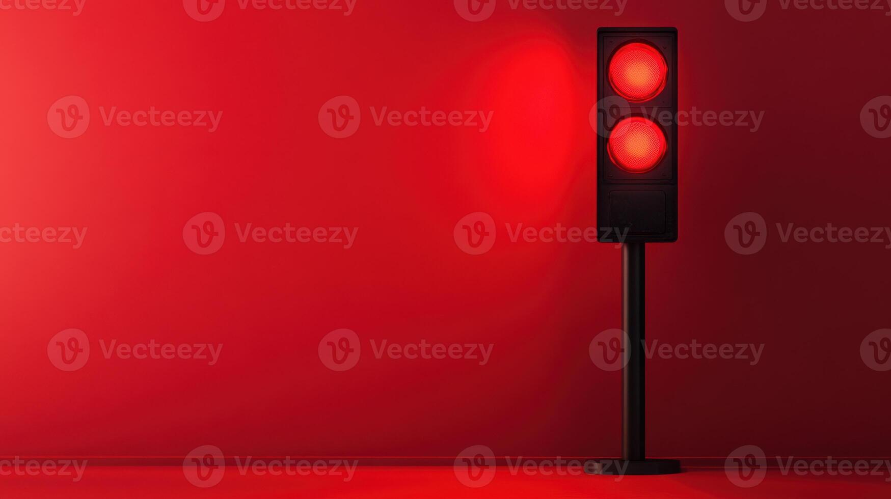 Red traffic light standing alone against a solid red wall in an urban setting at night photo
