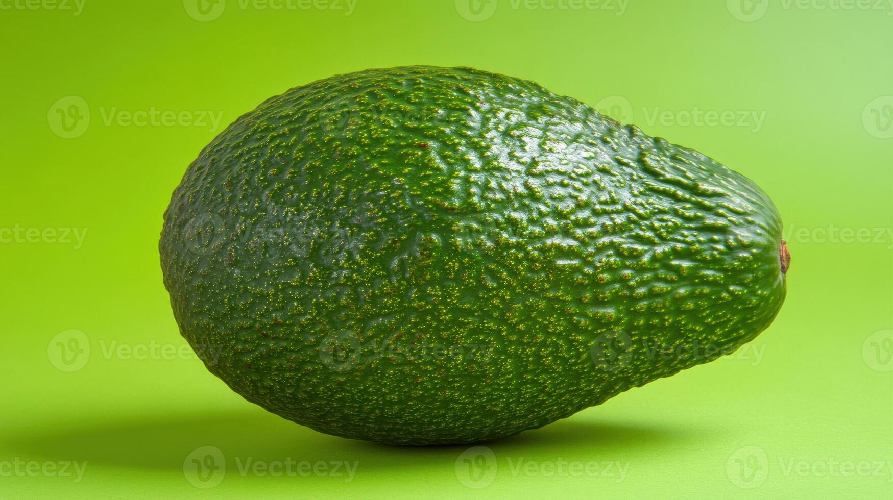 Fresh avocado on vibrant green background showcasing its texture and shape in a simple composition photo