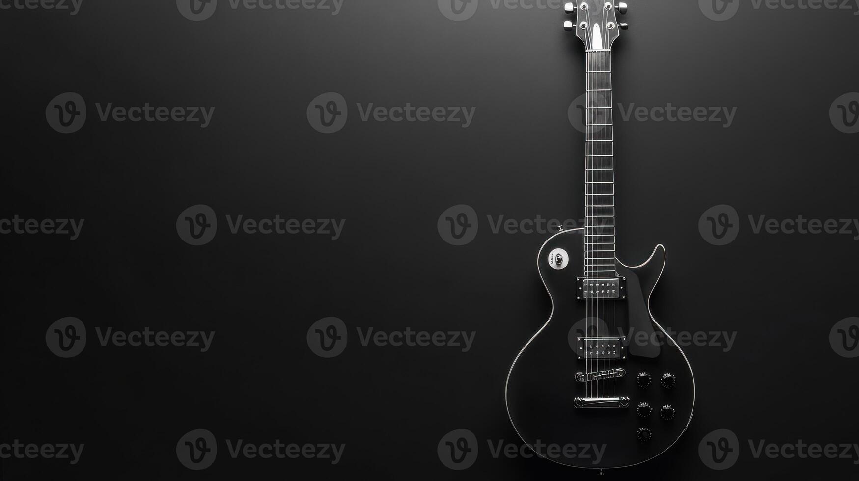 Beautiful black electric guitar hanging against a dark wall showcasing simple yet elegant design and craftsmanship photo
