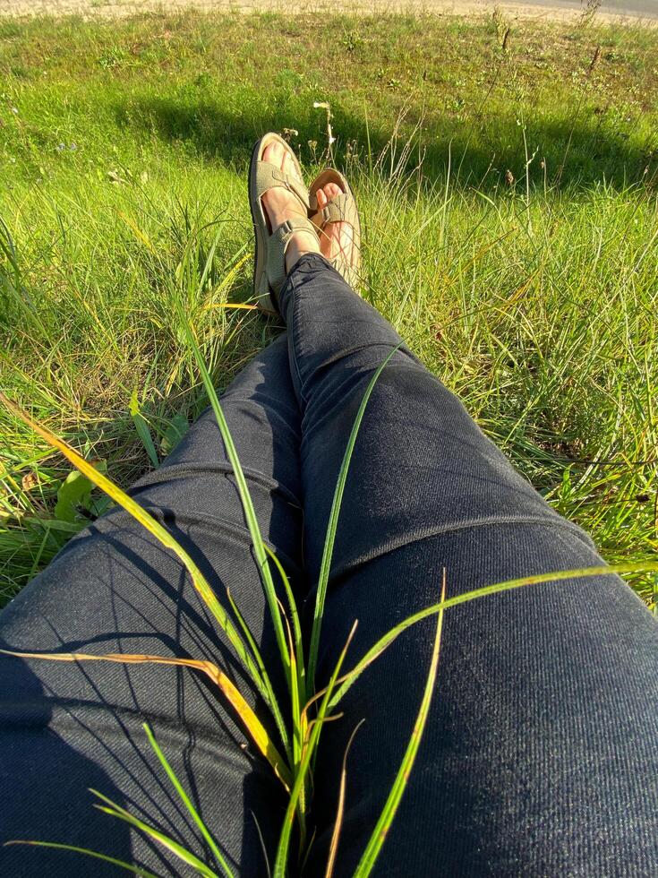 Beautiful women's legs on the grass, vertical image photo