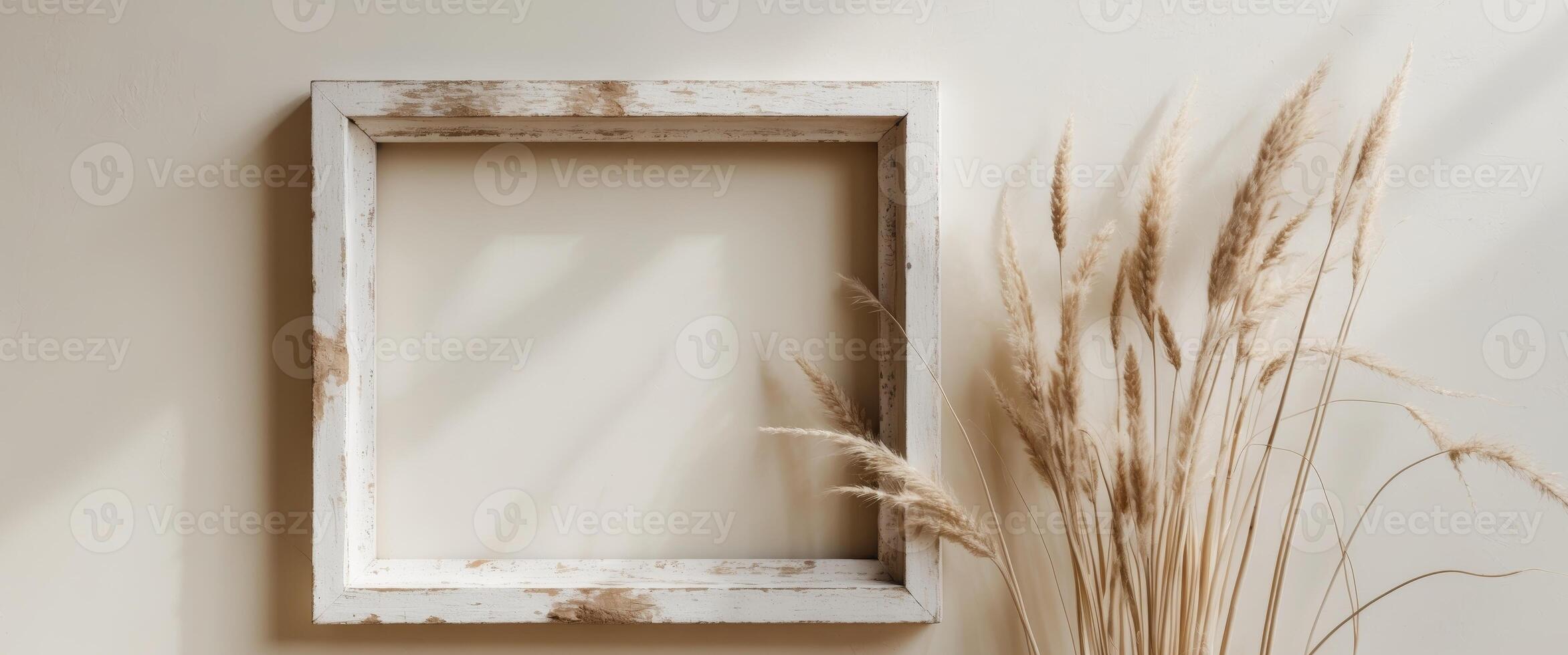 Rustic White Frame Hanging on a Wall Next to Dried Grass Stalks for a Natural Aesthetic photo