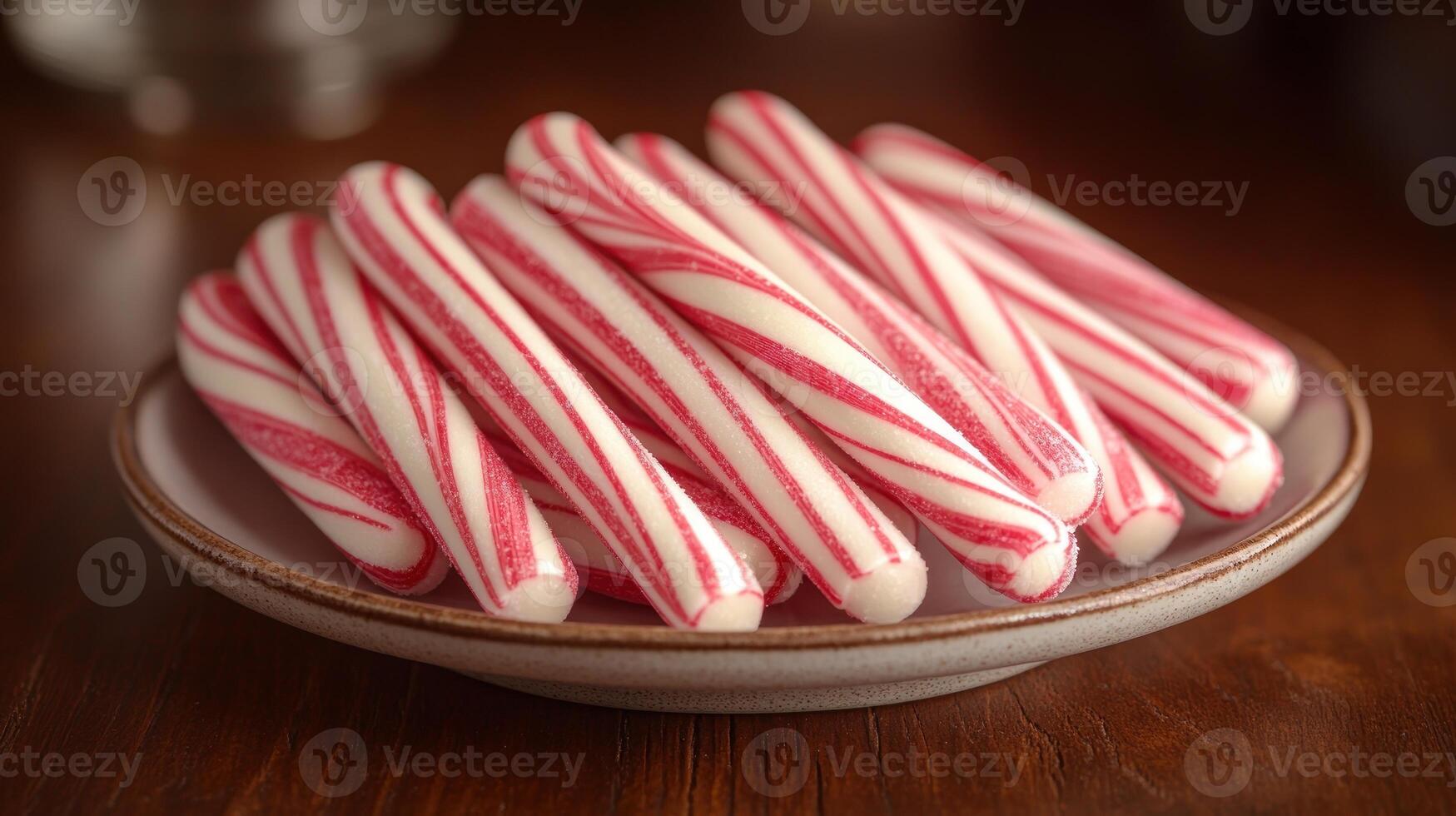 A vibrant collection of peppermint candy canes rests on an earthy plate, inviting joy photo