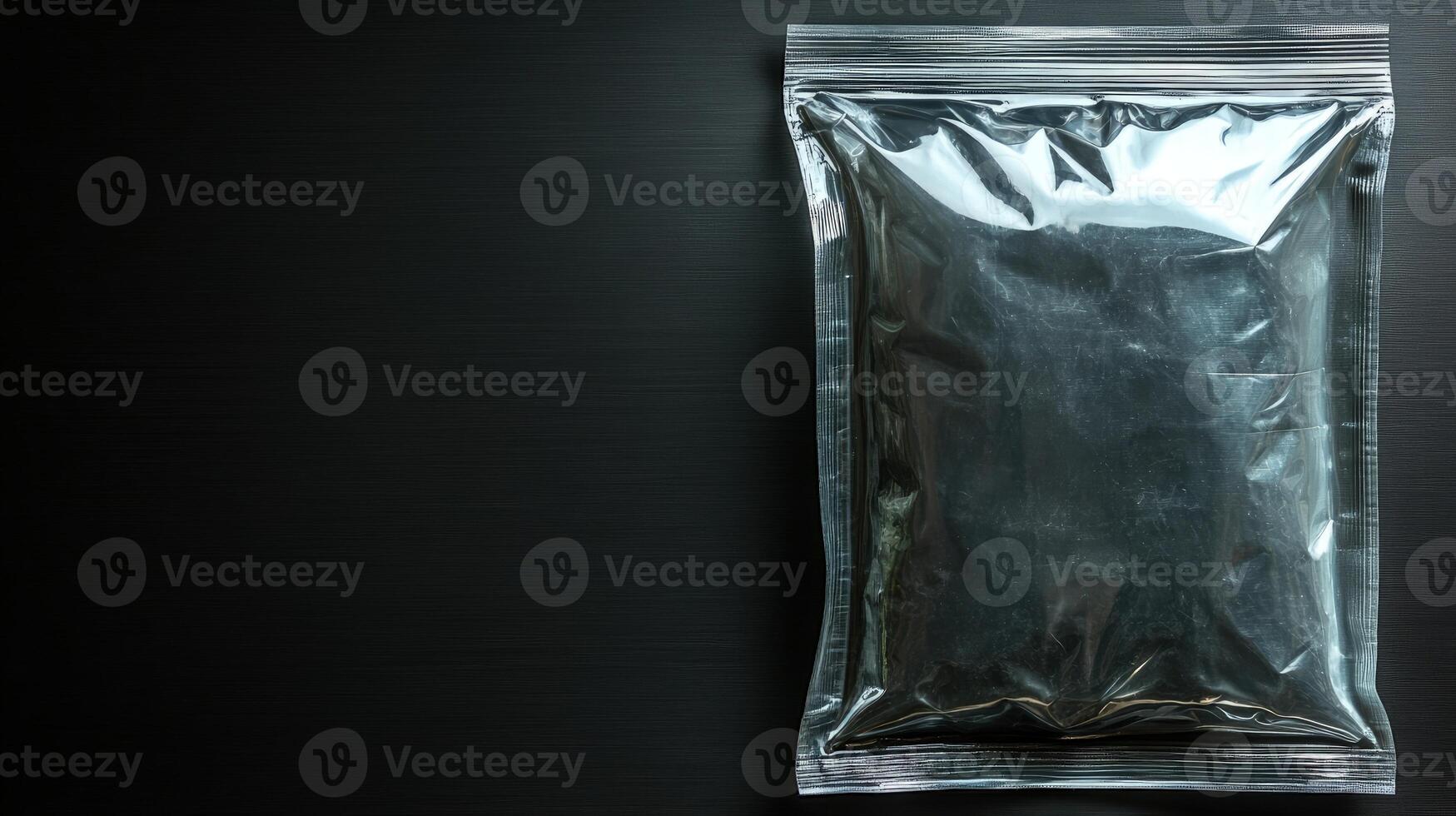 A shiny black package sits alone on a dark surface, creating intrigue and sparking imagination photo