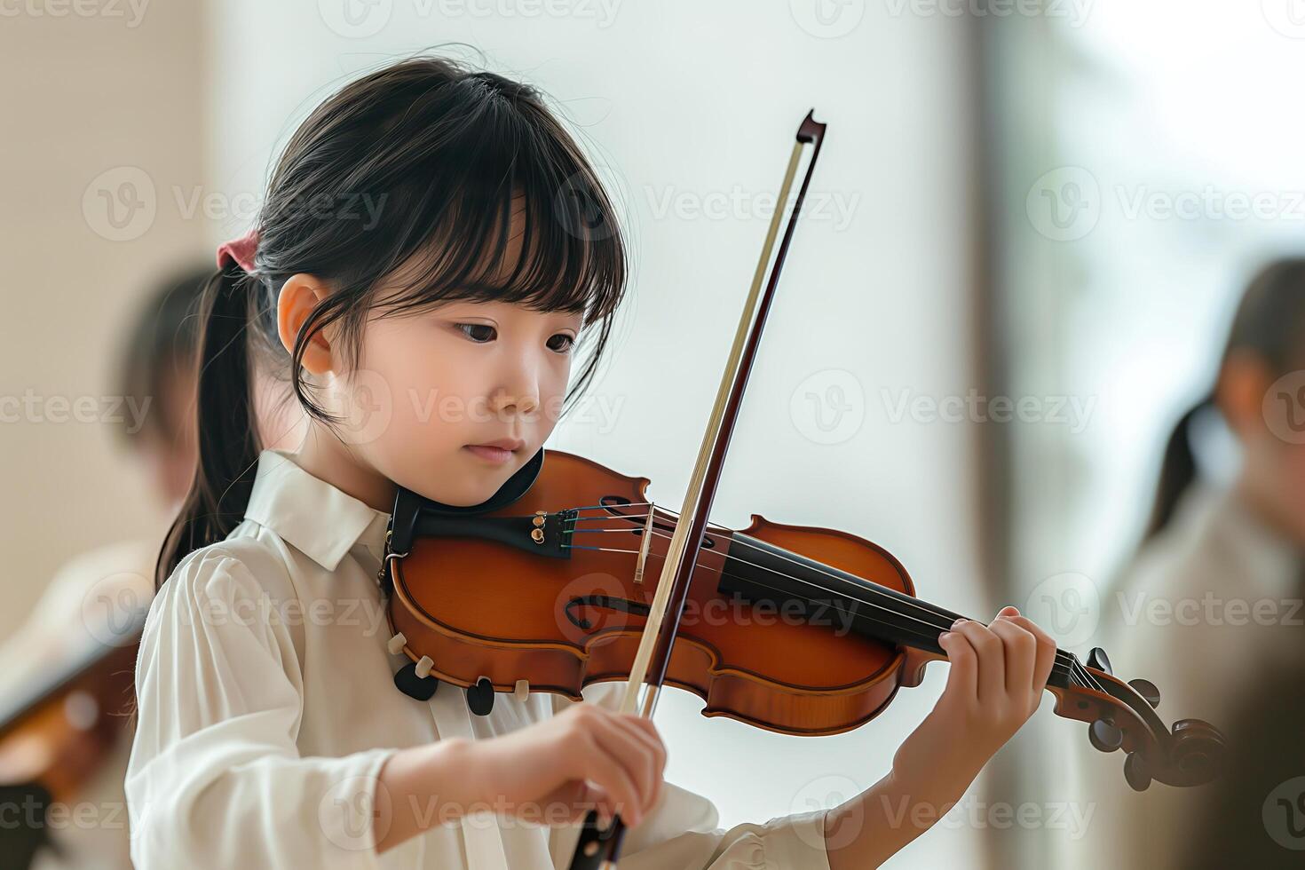 A young child skillfully plays a violin in a well-lit space, fully engaged in their music lesson photo