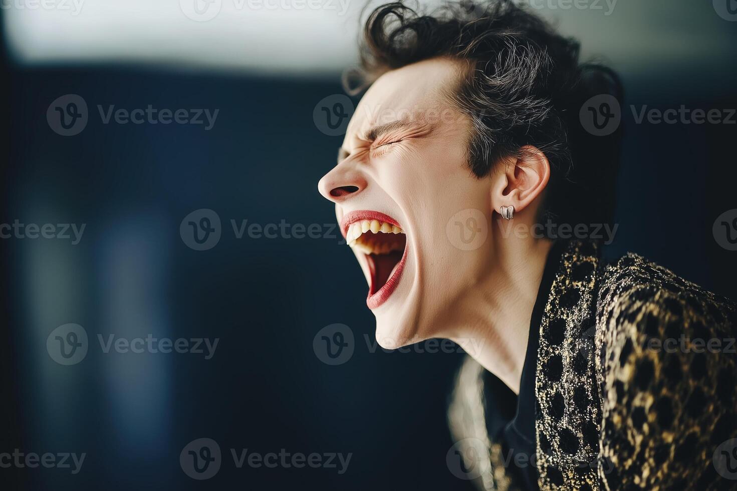 Portrait of a gender fluid drag queen laughing joyfully against a vibrant red background in a playful display of expression photo