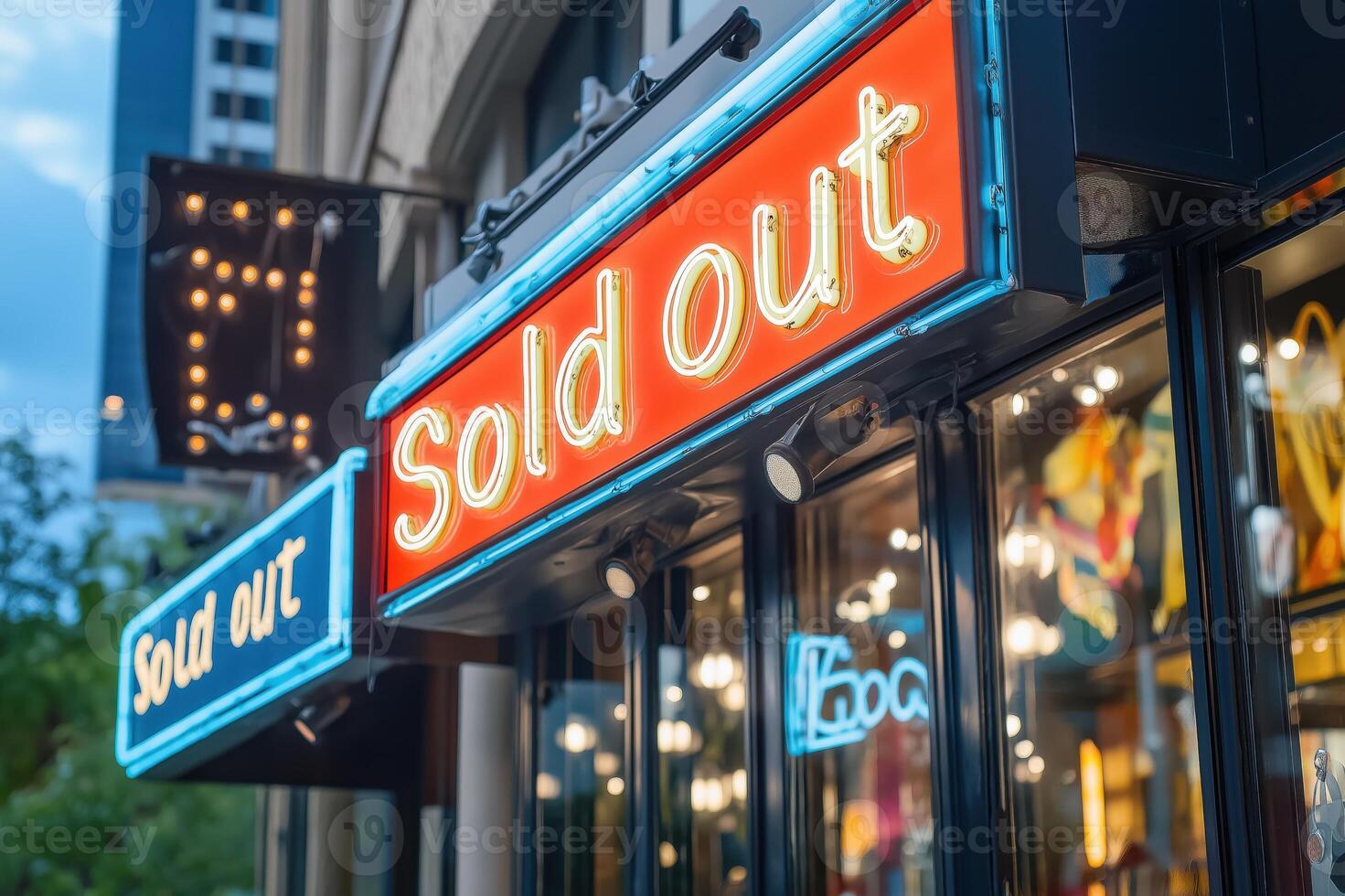 Brightly lit neon Sold Out sign outside a trendy retail store in an urban area during twilight photo