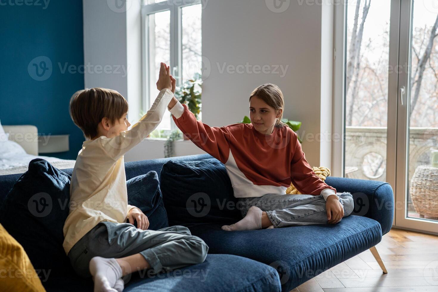 Older sister spending time with younger brother at home photo