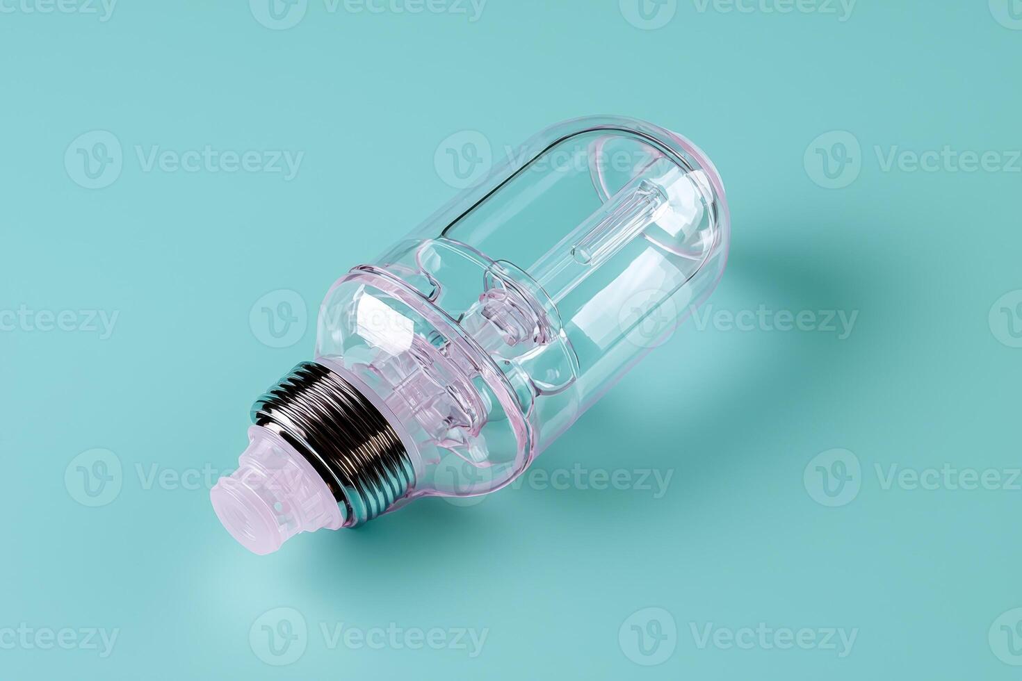 Empty transparent bulb shaped bottle with silver cap on a blue background photo