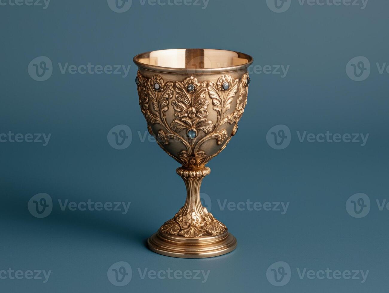 Ornate golden chalice with gemstone accents on a blue background photo