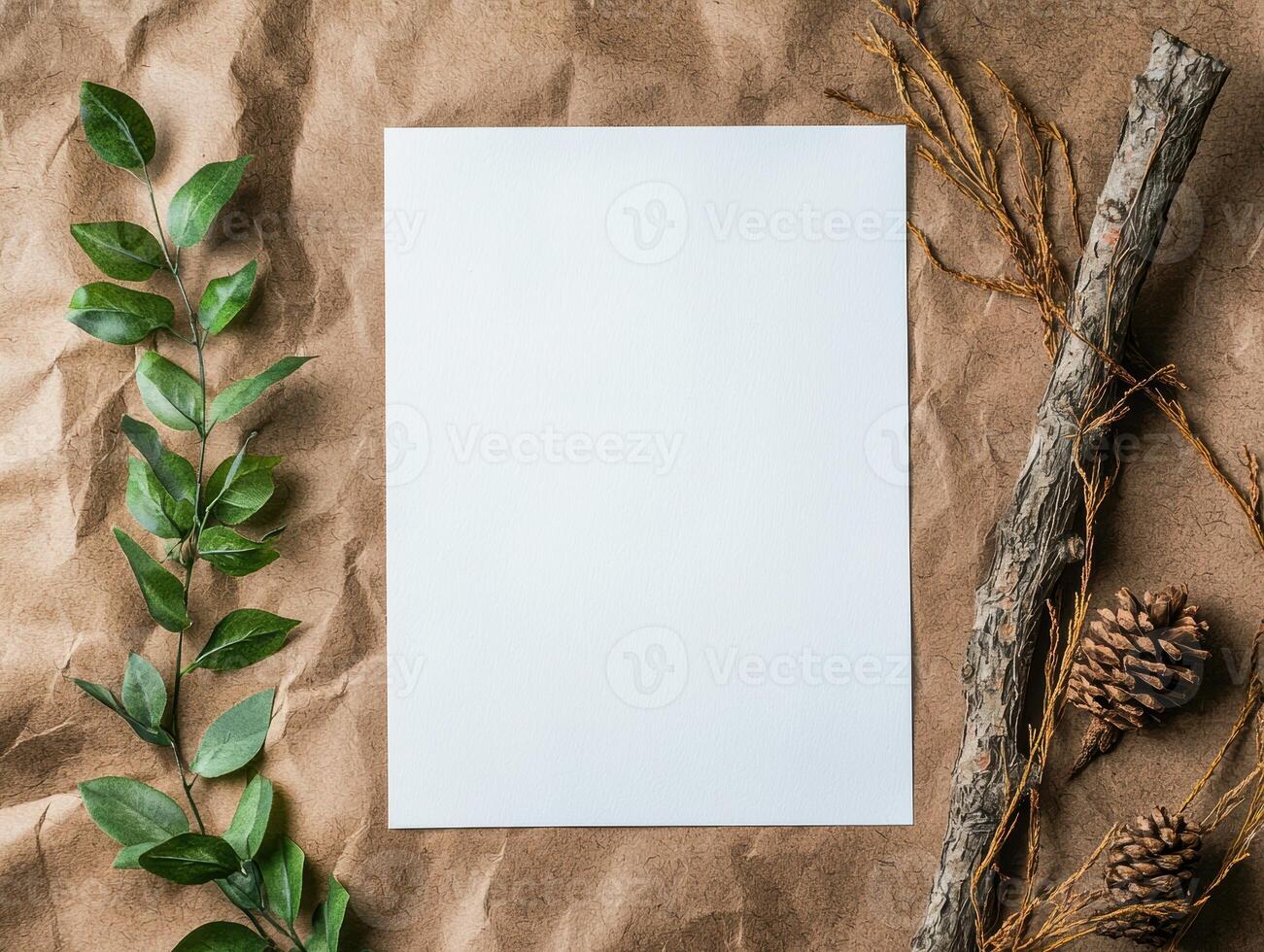Blank white paper mockup on crumpled brown paper background with green leaves and pine cones photo