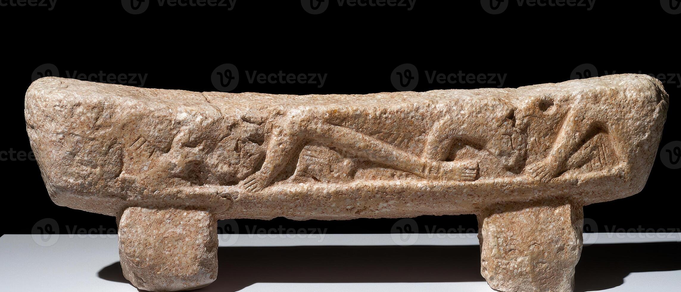 Ancient stone carving of reclining figures on a bench photo