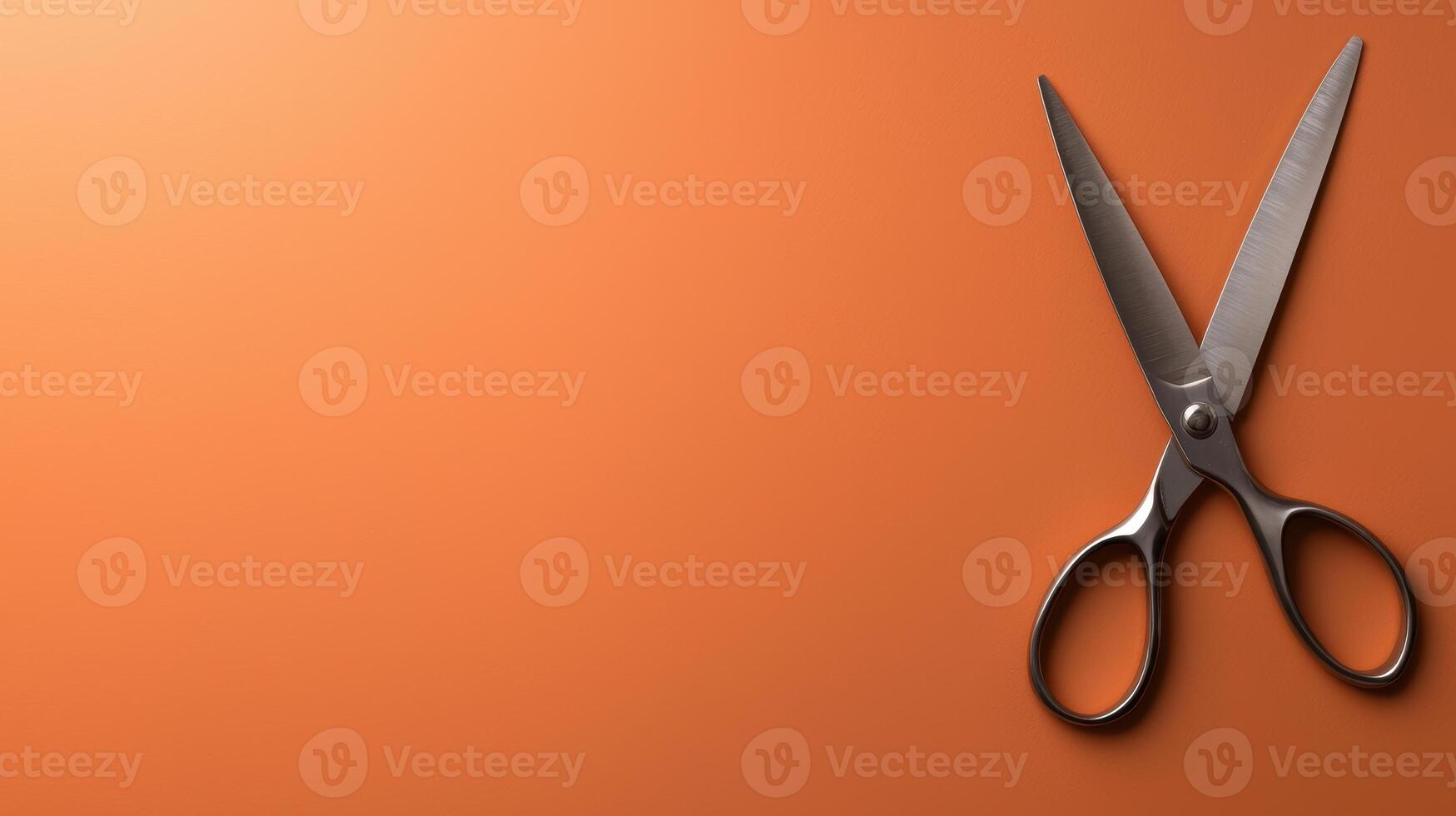 Silver scissors on orange background photo