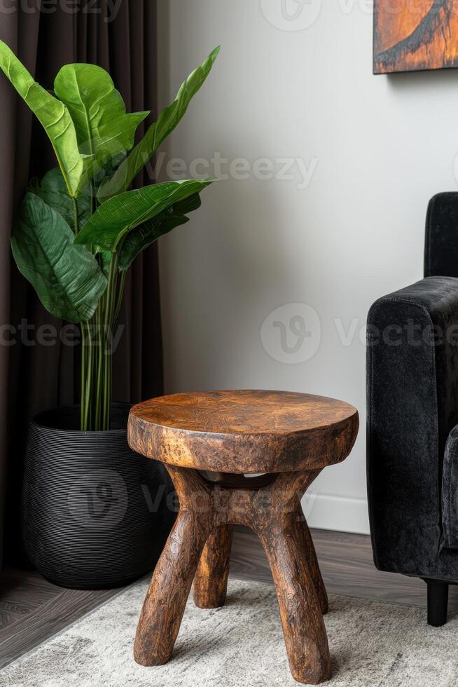 Modern living room with wooden stool, houseplant, and dark couch photo