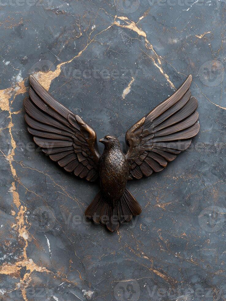 Bronze eagle sculpture on dark marble background photo