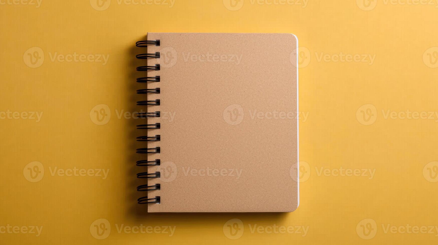 Blank spiral notepad mockup on yellow background photo